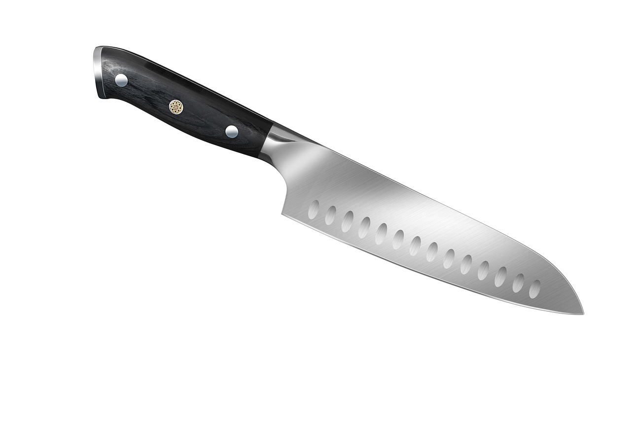 A chef's knife with a dark handle lying on a plain white background